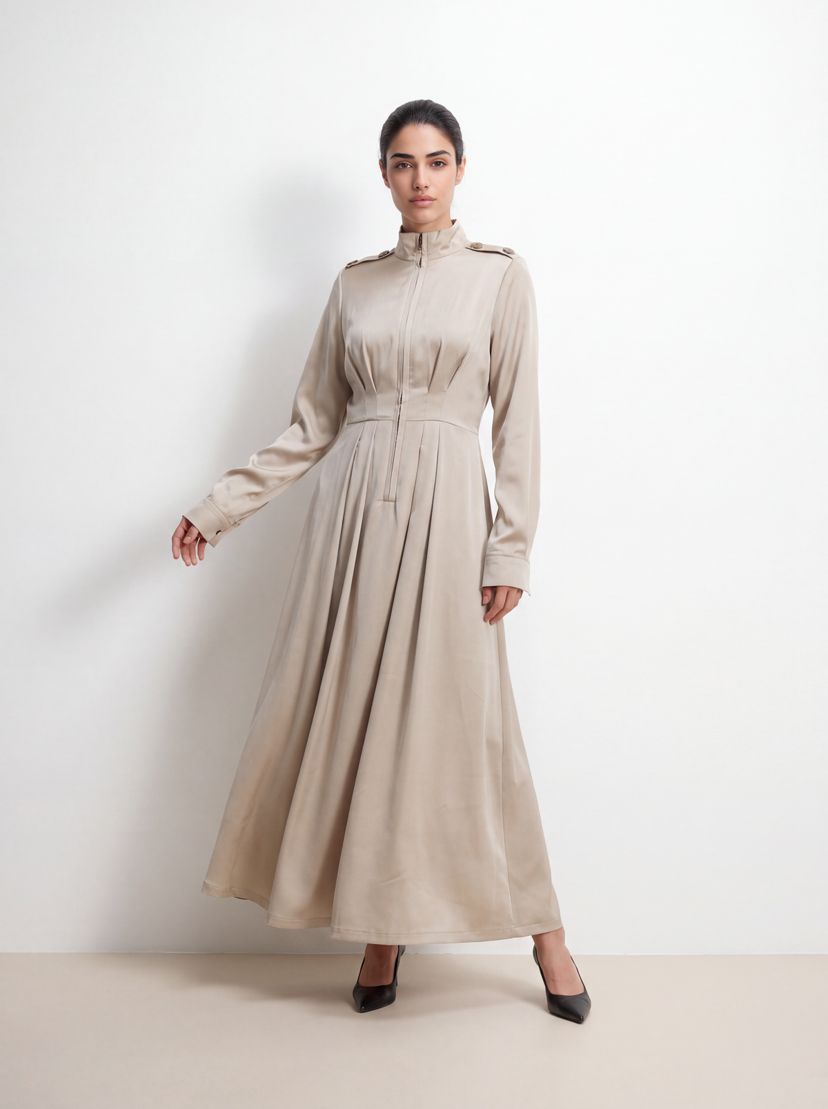 Full-length view of a woman wearing a light khaki utility-style maxi dress with a voluminous umbrella skirt and cinched waist.